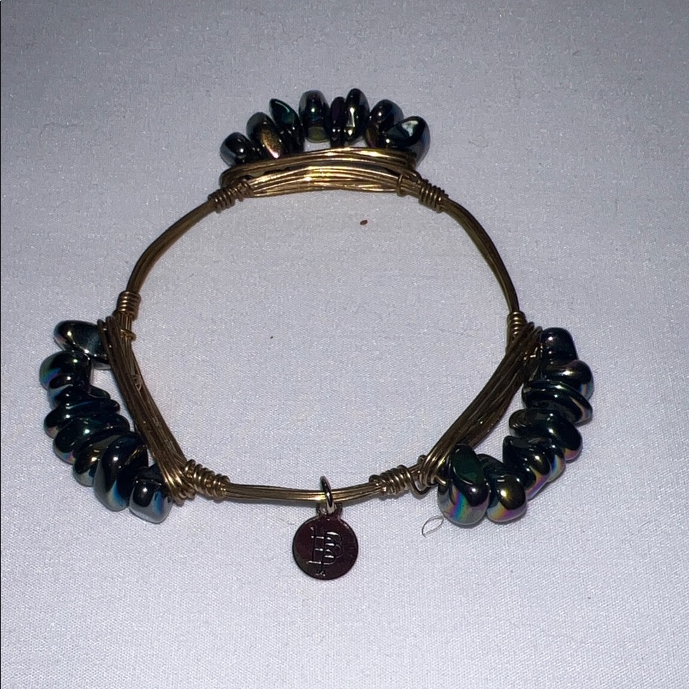 Bourbon and Boweties bangle features iridescent beads signature logo charm.